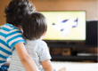 young children sitting in front of television